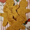 gingerbread-dog-biscuits-closeup-boo.jpg Close up of handmade gingerbread man dog biscuits with smiling faces, natural golden color on festive Christmas background