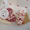 Love Bites Heart-Shaped Dog Cookies | Valentine Dog Treats UK Close up of Valentine dog treats UK showing Love Bites heart cookies with pink drizzle and sprinkles from Bow Wow Box