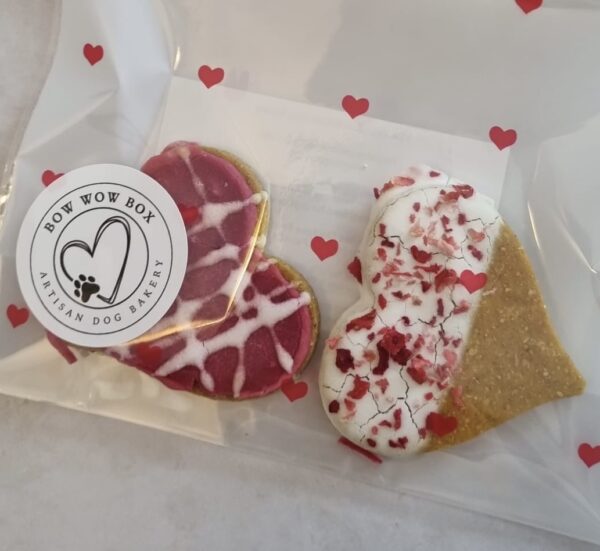 Love Bites Heart-Shaped Dog Cookies | Valentine Dog Treats UK Close up of Valentine dog treats UK showing Love Bites heart cookies with pink drizzle and sprinkles from Bow Wow Box