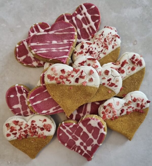 Love Bites Valentine Dog Treat Collection | Handmade in UK Collection of Love Bites Valentine dog treats UK showing variety of heart-shaped cookies with pink icing and sprinkles