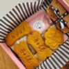 Bow Wow Box branded retail packaging Bow Wow Box branded gift box with personalised "Bolt" and "Woof" bone-shaped dog treats, a paw-shaped biscuit and a ribbon-tied treat bar